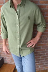 Camisa de lino azul marino para hombre, de corte oversize, con mangas largas, cuello camisero y cierre frontal con botones claros.