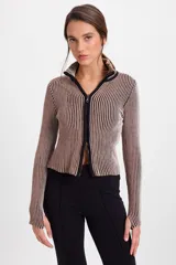 Campera corta de tejido de punto acanalado con diseño de rayas verticales en dos tonos. Presenta cuello alto y cierre frontal completo con borde en color negro.