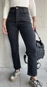 Pantalón de jean negro con costuras a la vista color ocre.