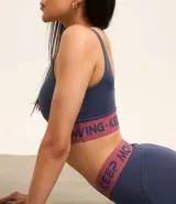 Legging deportiva de microfibra color lila, con cintura elástica ancha en contraste que presenta el texto Keep Mooving estampado.