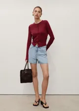 Short de denim celeste de tiro alto, corte recto y diseño de cinco bolsillos con trabillas y cierre frontal de cremallera y botón.