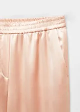 Pantalón de corte recto y diseño fluido con efecto satinado. Presenta cintura con elástico y dos bolsillos laterales.