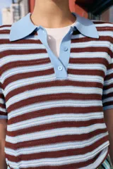 Top de punto de manga corta con diseño a rayas horizontales en tonos marrones y celestes, cuello polo liso en color celeste y cierre frontal con tres botones.
