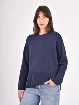 Buzo de tejido de punto en color azul marino, con cuello redondo y puños acanalados anchos. Presenta un diseño holgado con un panel inferior de tejido acanalado más grueso y aberturas laterales.