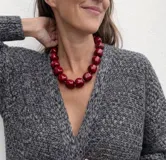 Collar de diseño artesanal compuesto por múltiples hileras de cuentas de resina pulida en una paleta de colores vibrantes que incluye tonos marrones, grises, verdes, naranjas y bordó.