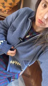 Saco tipo cardigan de punto jacquard color azul, con cierre frontal de aluminio. Presenta un diseño floral en la espalda y detalle de rombos en el ruedo y puños.
