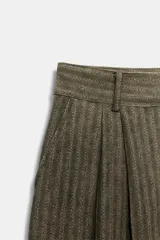 Pantalón de tiro medio con diseño de rayas verticales en tejido jacquard. Presenta pinzas en el delantero, cintura con trabillas, bolsillos laterales ocultos y cierre frontal con cremallera y botón.