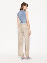 Pantalón ancho de cuero ovino color beige, con recortes verticales y horizontales, bolsillos delanteros tipo jean y bolsillos traseros tipo parche.