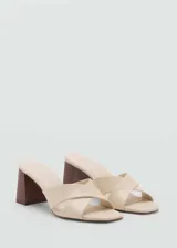 Sandalias de tacón bloque estilo destalonado, con diseño de tiras cruzadas en el empeine, puntera abierta y taco de madera oscuro.
