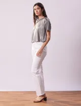 Blusa gris metalizada de tejido lurex, marca June & Hudson, con cuello redondo y ruedo con nudo en la espalda.