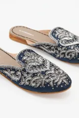 Zuecos negros con bordados dorados y canutillos. Taco de madera de 1,5 cm y forro interior de gamuza.