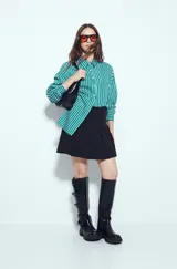 Minifalda tableada de color negro, con diseño de tablas anchas que aportan volumen y movimiento. Presenta un corte estructurado y un calce cómodo.