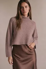 Polera de punto acanalado con cuello alto, diseño holgado y mangas largas con corte raglán.