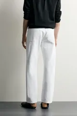 Jeans regular fit de corte recto y tiro medio, confeccionados en denim de algodón blanco con diseño de cinco bolsillos y cierre frontal con cremallera y botón.