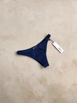 Bombacha de bikini vedetina con estampado geométrico en tonos naranja, celeste y rosa.