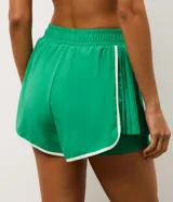 Bermuda deportiva tipo runner color verde, confeccionada en microfibra liviana. Presenta cintura elástica, short interno integrado para mayor seguridad y detalles de friso en color blanco en los bordes redondeados.