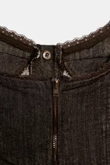 Top crop de denim color marrón oscuro con detalles de encaje translúcido en los laterales, escote redondo, tirantes anchos y cierre frontal con botones metálicos.