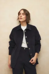 Sobrecamisa de pana color verde oscuro, con cuello camisero, cierre frontal de botones metálicos y manga larga. Presenta un diseño de corte recto y holgado.