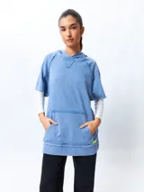 Chaleco negro lavado de algodón con capucha y gran bolsillo central. De corte oversized, holgado, suave y cómodo.