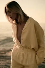 Camisa amarilla de lino con cuello solapa, escote pico, manga larga con botones y cierre frontal con botones.