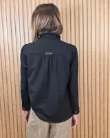 Camisa de denim negra con cuello mao y cierre frontal con botones. Cuenta con detalles de volados sutiles a lo largo de la botonera, costuras en contraste y frunces en los hombros.