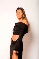 Top negro con escote bardot, mangas largas y fruncido en el centro.