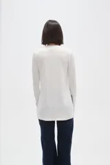 Remera de manga larga con cuello a la base, confeccionada en tejido de punto canalé con diseño holgado.