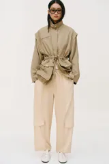 Pantalón de tiro medio con cintura elástica ajustable con cordón. Presenta un diseño de paneles laterales en tejido técnico contrastante y bolsillos tipo cargo. Su corte es holgado con pernera que se estrecha hacia el tobillo.