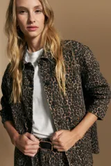 Sobrecamisa de corte relajado con estampado animal print, cuello camisero, cierre frontal con botones y bolsillos aplicados.