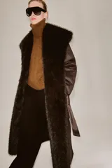 Abrigo largo de Zara Woman Collection en color marrón chocolate, con cuello de solapa amplio, mangas largas y cinturón ajustable del mismo tejido. Presenta detalles de forro interior y acabados en efecto pelo a tono en cuello, puños y bordes frontales.