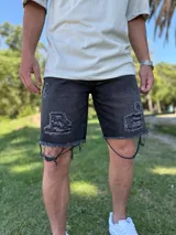 Bermuda de jean celeste con roturas y detalles deshilachados en el ruedo.