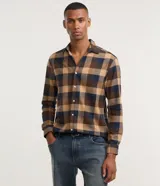 Camisa de algodón con estampado de cuadros en tonos azul, blanco y gris. Cuenta con cuello camisero, mangas largas abotonadas y corte comfort.