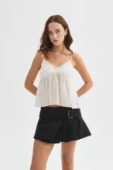 Musculosa blanca de lyocell, con tirantes finos regulables, escote en V y detalle de volados en el delantero, de diseño holgado.