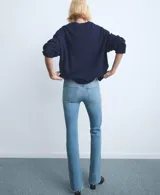 Jeans de corte recto y tiro medio, confeccionados en denim de algodón con un toque de elastano. Presentan un acabado clásico en tono azul claro con bajo desflecado.
