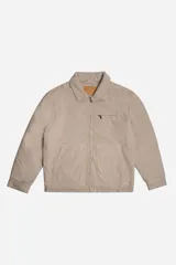 Campera de canvas color beige con cierre frontal, cuello camisero, dos bolsillos frontales abiertos y un bolsillo superior con cierre. Diseño de estilo utilitario con estructura firme.