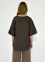 Blusa blanca de lino con escote en V y mangas cortas amplias.