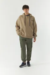 Canguro de felpa color beige con capucha, cordones negros, bolsillo tipo canguro y puños y cintura acanalados. Estampado con el logo de la marca en el pecho y parche con el logo en la manga izquierda.