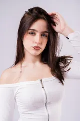 Remera de morley color blanco, con escote off-the-shoulder y cierre frontal metálico plateado. Es de manga larga y diseño ajustado al cuerpo.