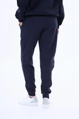 Pantalón de jogging de felpa, color beige, con cintura elástica ajustable mediante cordón y puños acanalados en los tobillos.