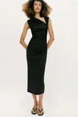 Vestido midi negro con escote asimétrico, sin mangas y detalle de drapeado delantero.