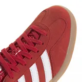 Championes adidas Gazelle Indoor de diseño clásico, confeccionados en gamuza color rojo con las icónicas tres tiras laterales en blanco. Presentan talón en contraste blanco, lengüeta con textura y suela de goma color caramelo.