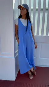 Mono largo de lino color beige, con breteles finos ajustables que se atan en la espalda, corte holgado y bolsillos laterales.