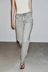 Jeans de tiro alto, pernera recta y larga, estilo clásico con cinco bolsillos, cierre frontal con cremallera y botón metálico.