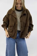Campera de pana marrón, de corte corto y diseño abullonado en las mangas, con bolsillos frontales con solapa y cierre de botones.