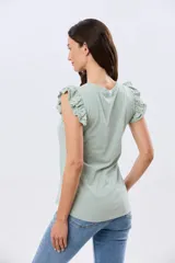 Remera de algodón azul melange con escote redondo y mangas cortas adornadas con doble volado de broderie en los hombros.