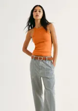 Musculosa de tejido acanalado en color naranja, con cuello redondo alto y detalle de pequeño bordado central en el pecho.