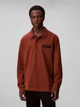 Chomba de manga larga Calvin Klein color marrón, con cuello clásico, cierre frontal con botones y logo bordado en el pecho.