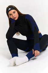 Conjunto deportivo de tres piezas compuesto por una campera corta con cierre frontal, un top deportivo y una calza larga. Las prendas presentan un diseño texturizado en color negro con detalles en azul eléctrico en los laterales y pretinas.