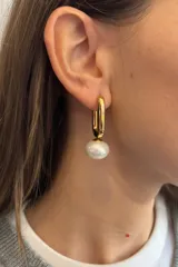 Aros tipo argolla alargada de acero dorado con dije de perla colgante.