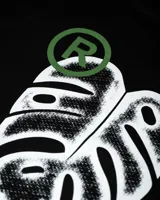 Remera de diseño doble capa con cuerpo negro de algodón y mangas largas tejidas en color blanco. Presenta un corte boxy relajado, cuello redondo y el logo de la marca estampado en pequeño en el pecho.